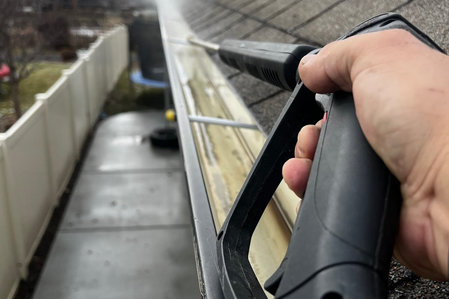 Professional gutter cleaning equipment clearing a residential gutter