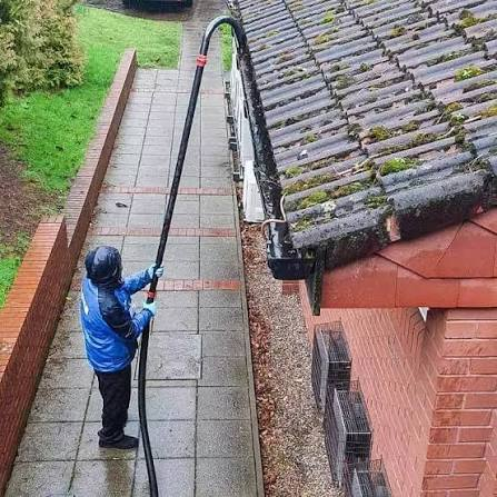 Professional gutter vacuum equipment being used on a residential property