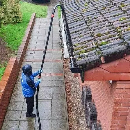 Professional gutter vacuum equipment being used on a residential property