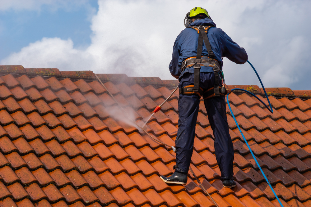 Professional roof cleaning being carried out on a tiled property
